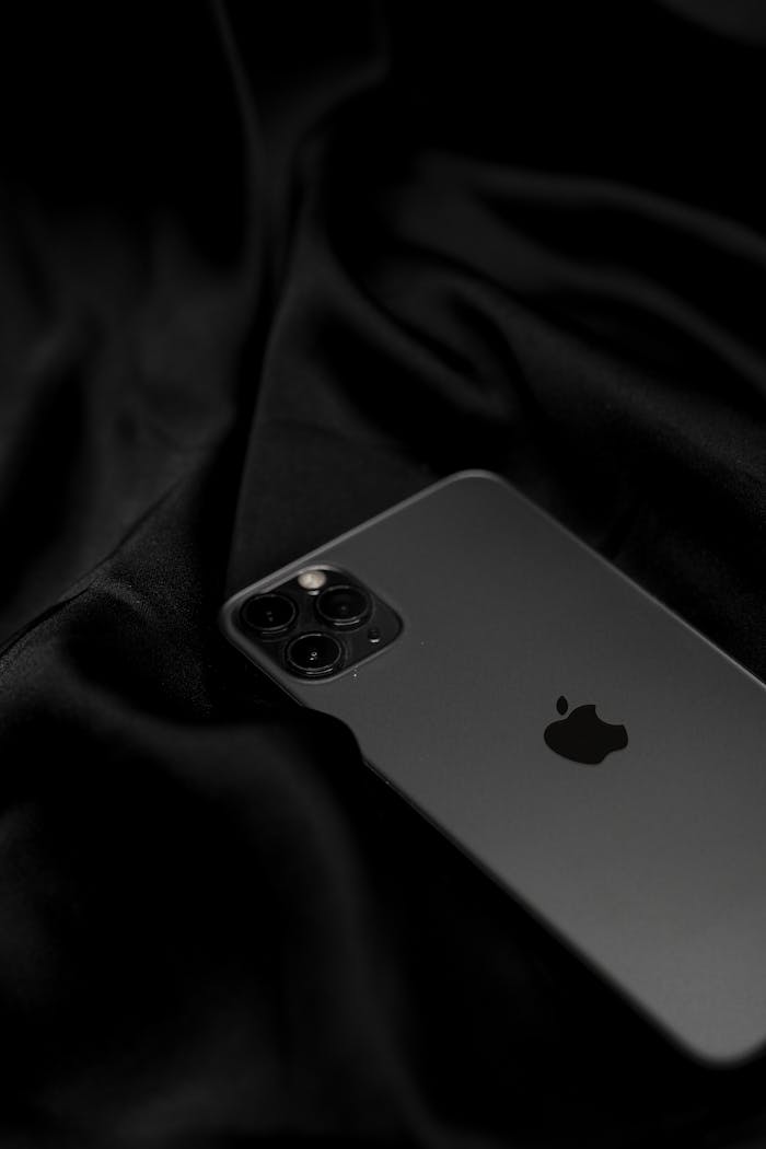 services-04 Stylish black smartphone on sleek satin fabric, showcasing modern technology design.